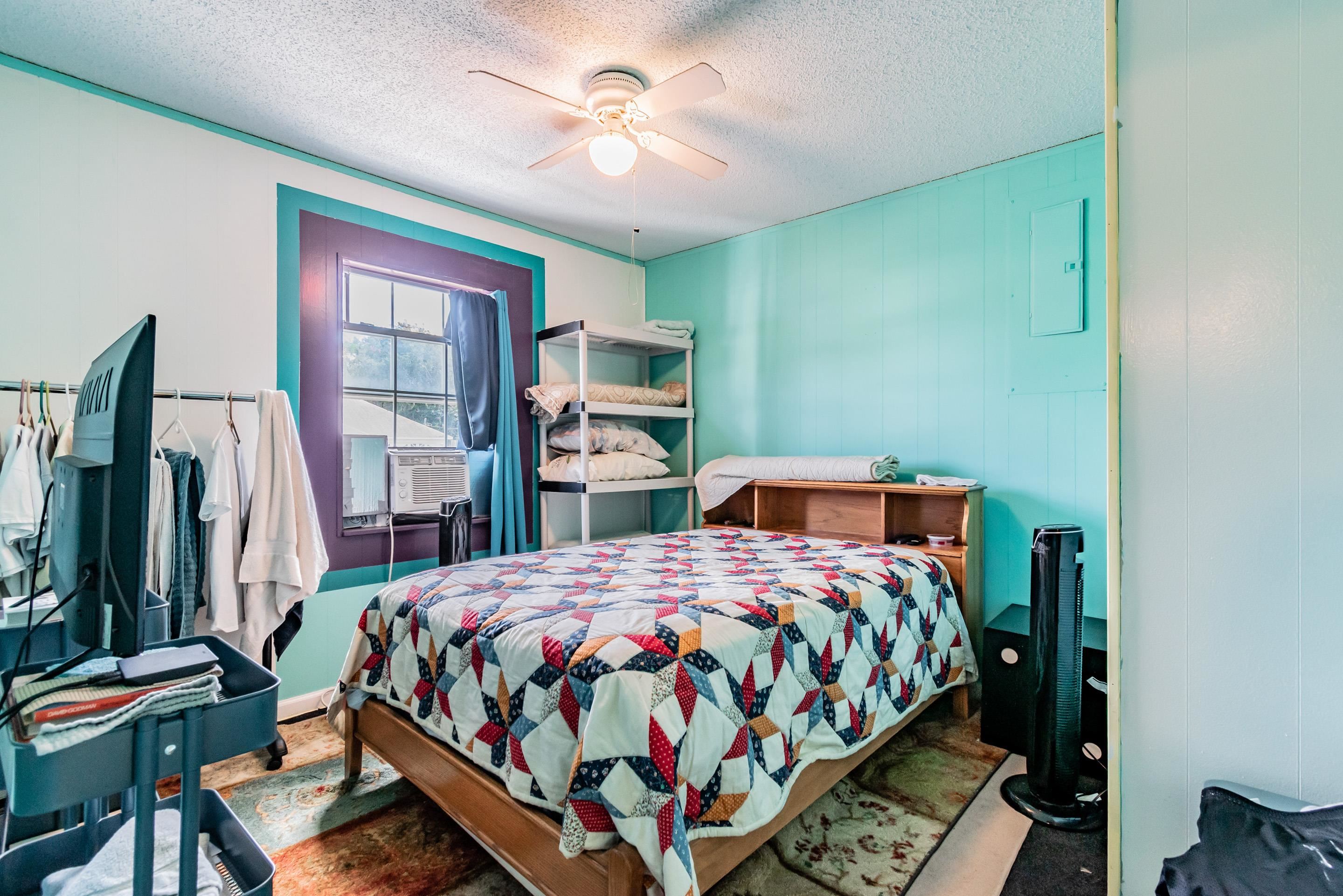 238 Cornell Road St. Augustine, FL 32086 - Photo 16 of 33 a bedroom with a bed a chandelier and dresser