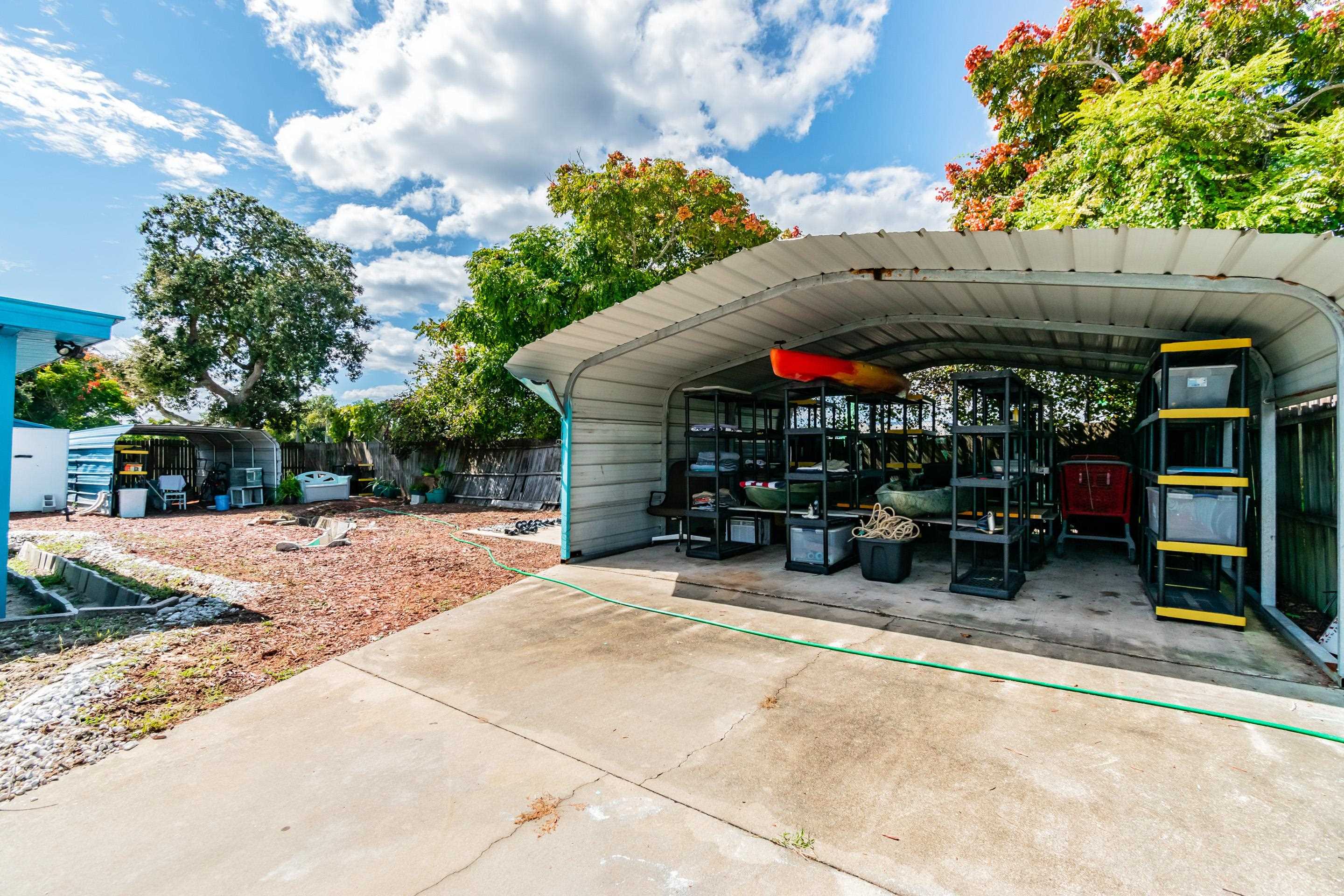 238 Cornell Road St. Augustine, FL 32086 - Photo 24 of 33 a view of a patio with table and chairs under an umbrella with large trees