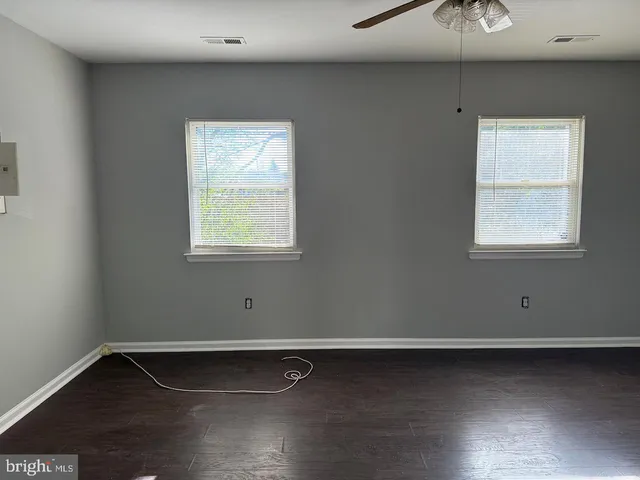 a view of a room with wooden floor and a window