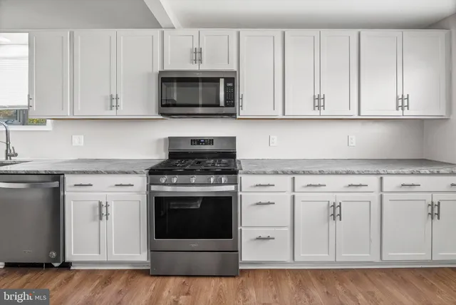 a kitchen with white cabinets and stainless steel appliances