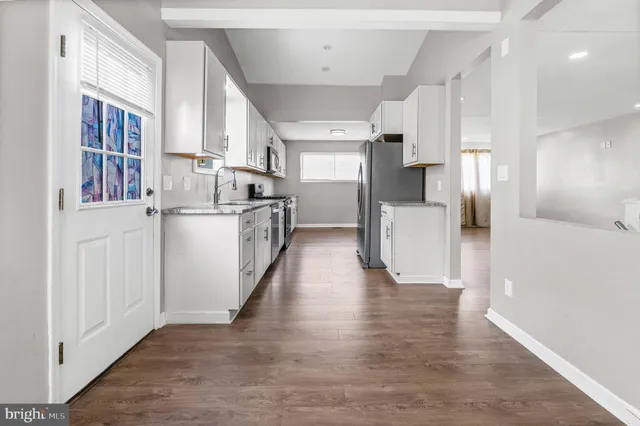 a view of a kitchen with a refrigerator and a sink