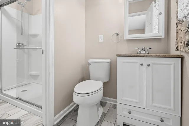 a bathroom with a granite countertop toilet sink and shower
