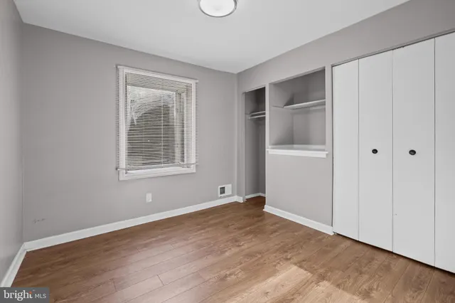 an empty room with windows and closet