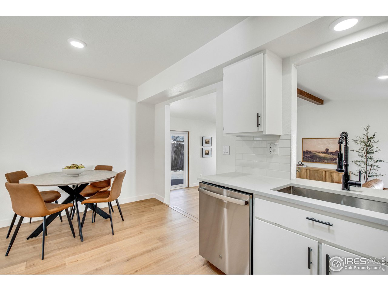 1115 2nd Street Road Eaton, CO 80615 - Photo 10 of 39 a kitchen with stainless steel appliances kitchen island granite countertop a table chairs in it and white cabinets