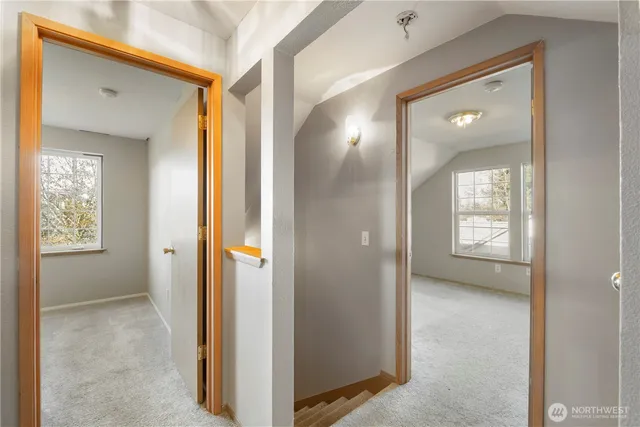 a view of a hallway with wooden floor and a living room