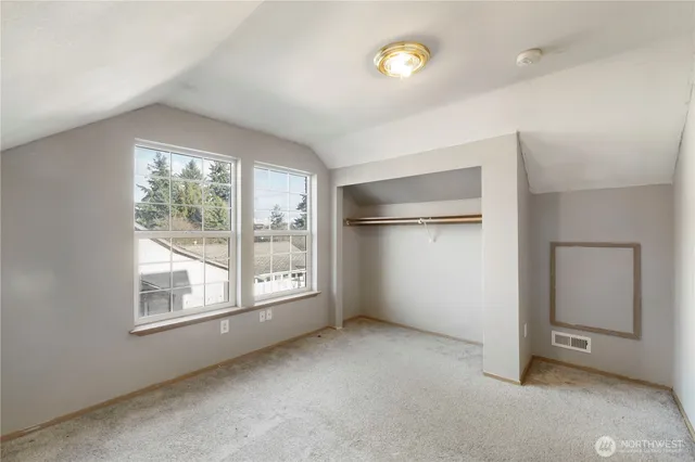 an empty room with windows and closet