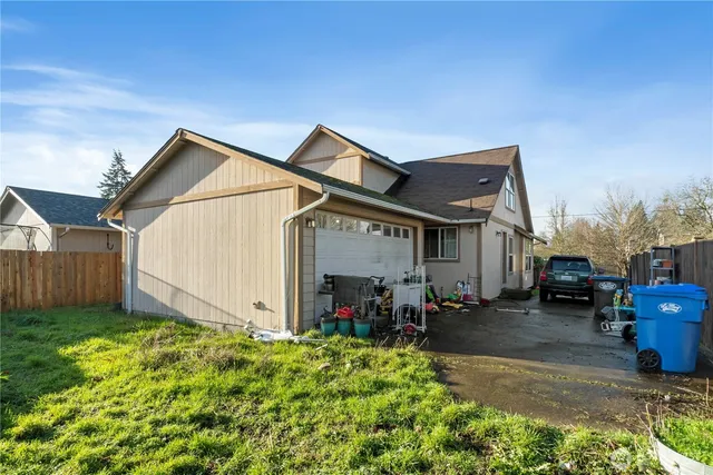 a view of a house with a yard and lawn chairs with a fire pit