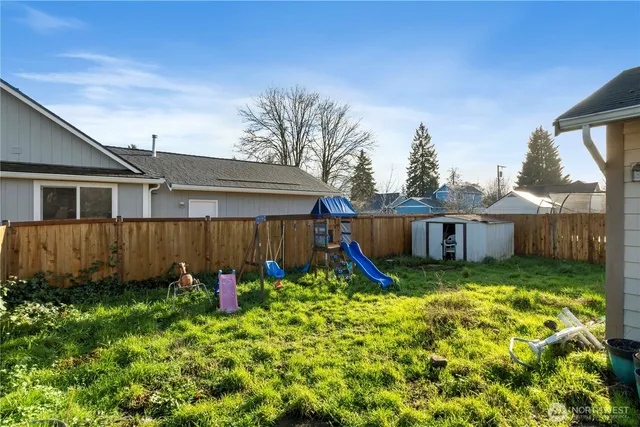 a view of a backyard with potted plants and wooden fence