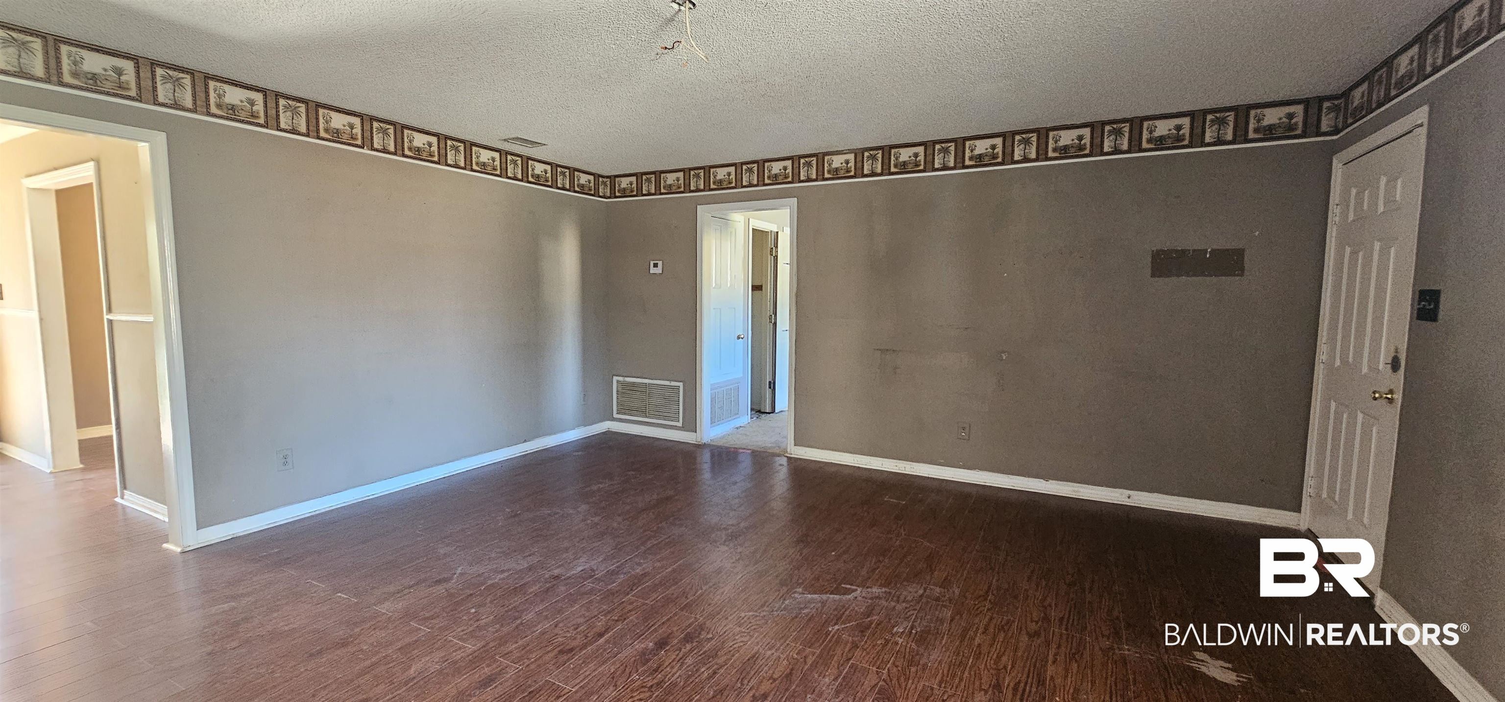 151 Bullard Street Atmore, AL 36502 - Photo 5 of 38 Spare room featuring dark wood finished floors and a textured ceiling