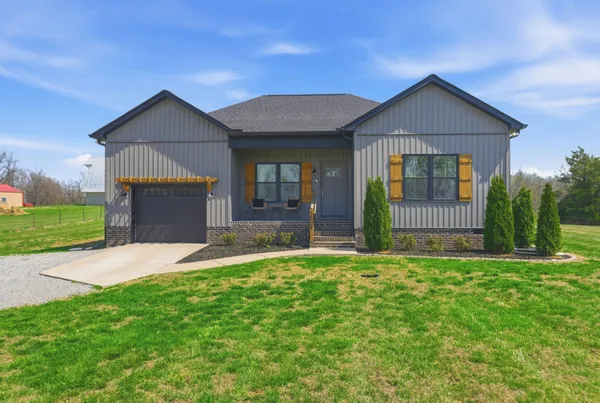 a front view of a house with a yard and garage