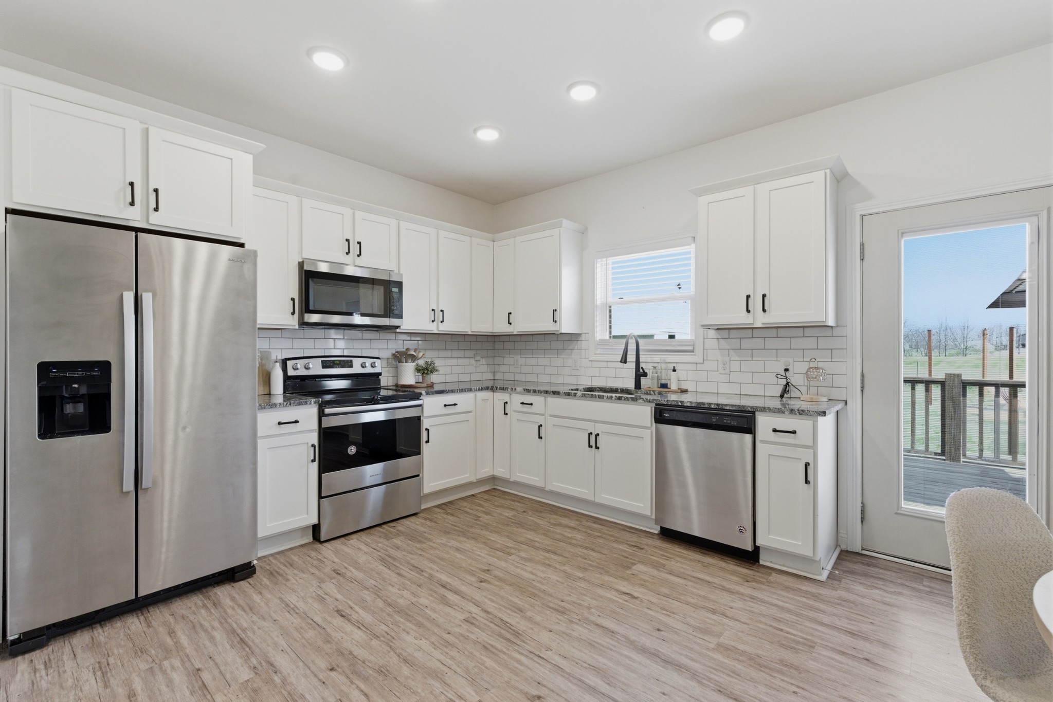 1502 Rock Bridge Road Bethpage, TN 37022 - Photo 8 of 40 a kitchen with granite countertop white cabinets and stainless steel appliances