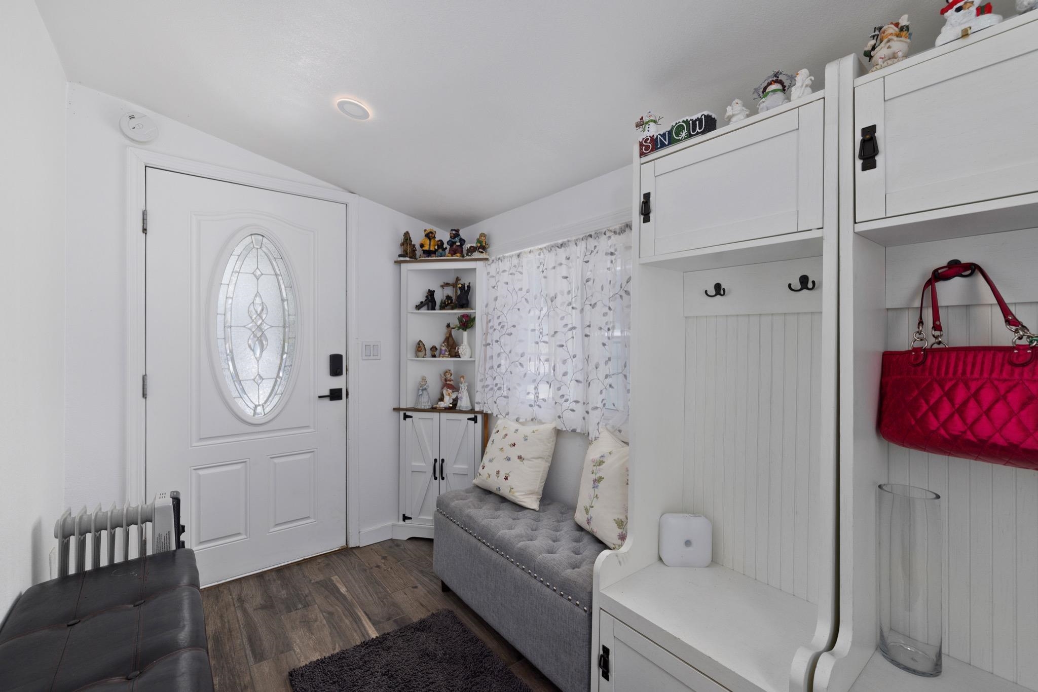 100 Ski Trails Road, Unit 10 Mammoth Lakes, CA 93546 - Photo 2 of 26 Entryway featuring a white door with an oval leaded glass insert, wood-finish flooring, and built-in white cabinetry with beadboard paneling
