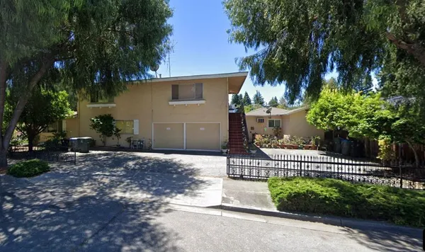 a view of a house with a yard and tree s