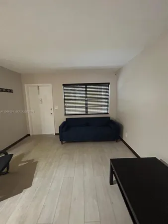 a living room with a bed and a night stand