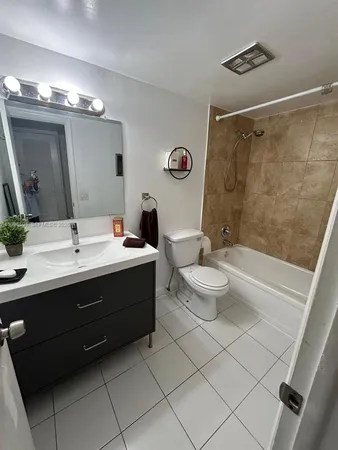 a bathroom with a double vanity sink toilet mirror and shower