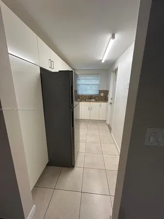 a kitchen with a refrigerator and a stove top oven