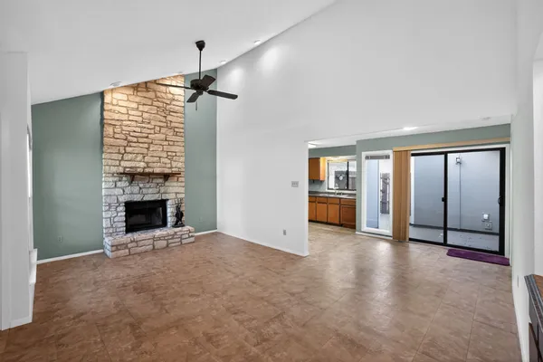 an empty room with windows and fireplace