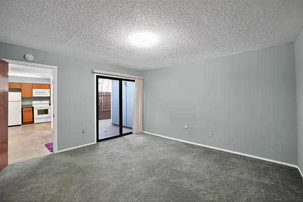 an empty room with sliding door and balcony view