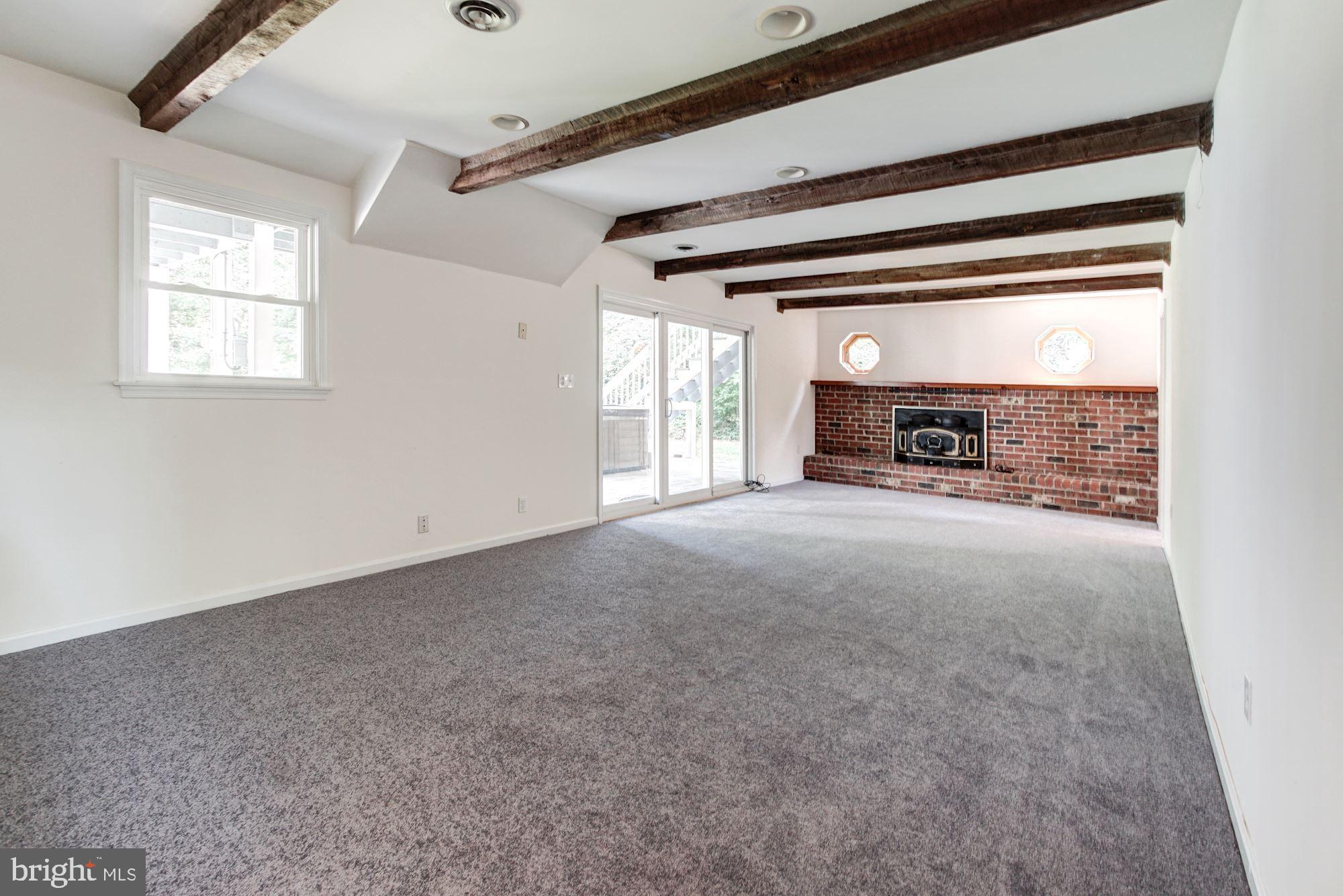471 Fairhaven Road Tracys Landing, MD 20779 - Photo 20 of 40 a view of a livingroom with a fireplace a ceiling fan and windows