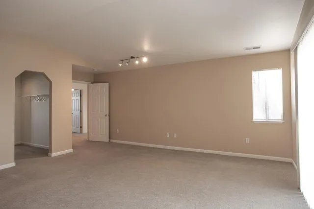 an empty room with windows and closet
