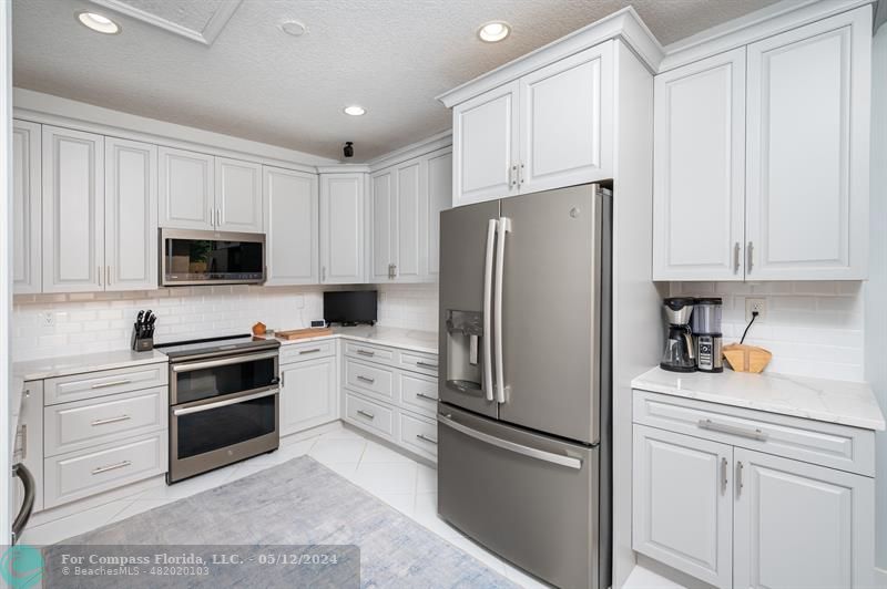 11285 Sunview Way Hollywood, FL 33026 - Photo 11 of 33 a kitchen with white cabinets and stainless steel appliances