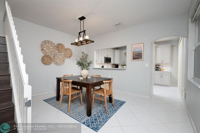 11285 Sunview Way Hollywood, FL 33026 - Photo 8 of 33 a dining room with wooden floor a chandelier a wooden table and chairs