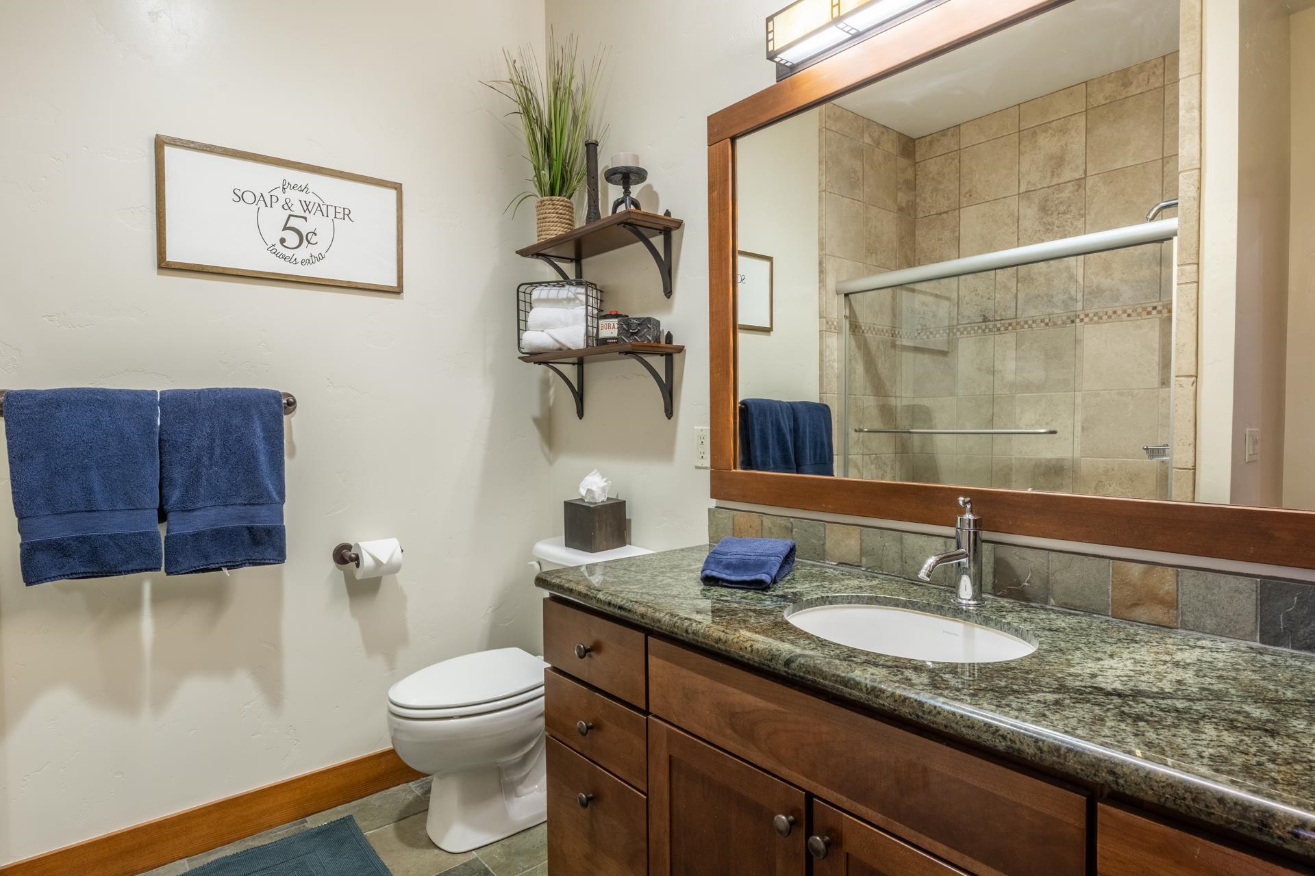 125 Davison Road, Unit 1 Mammoth Lakes, CA 93546 - Photo 29 of 46 a bathroom with a granite countertop sink a toilet and a mirror