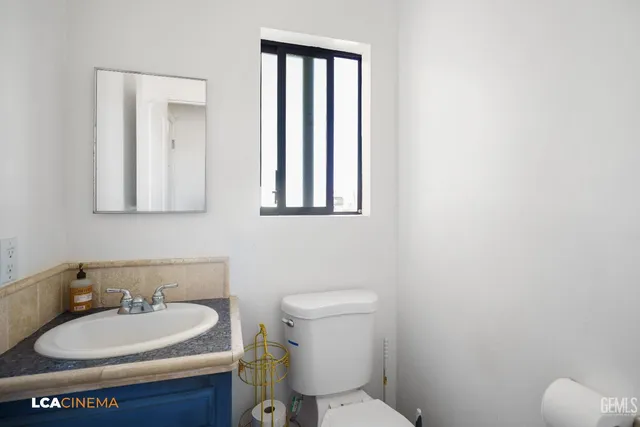 a bathroom with a toilet sink and mirror