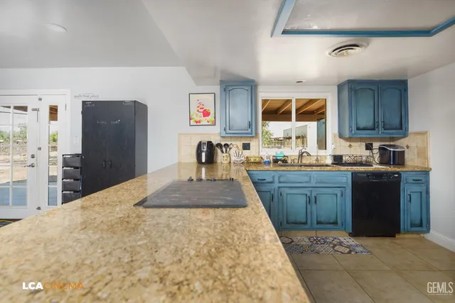 a kitchen with granite countertop a refrigerator stove top oven and sink