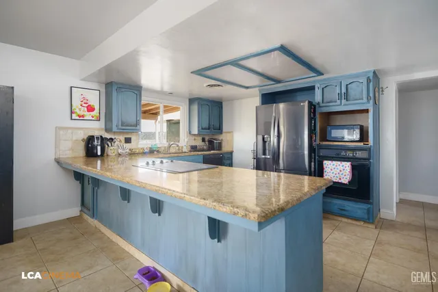 a kitchen with stainless steel appliances granite countertop a sink and a refrigerator