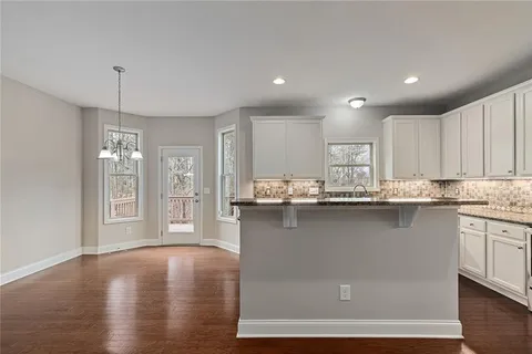a kitchen with granite countertop a sink stove and cabinets