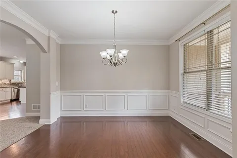 wooden floor in an empty room with a chandelier fan