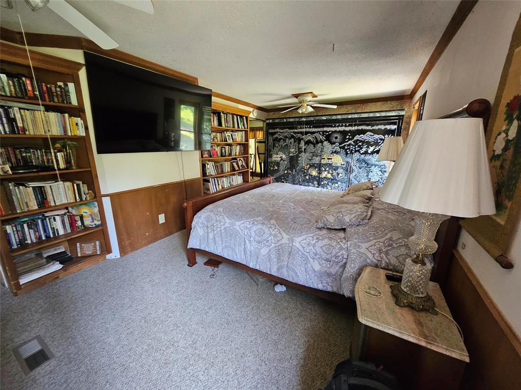 16307 County Road Henderson, TX 75654 - Photo 13 of 27 a bedroom with a bed and a book shelf