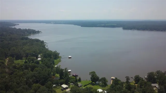 an aerial view of residential house with outdoor space and trees all around