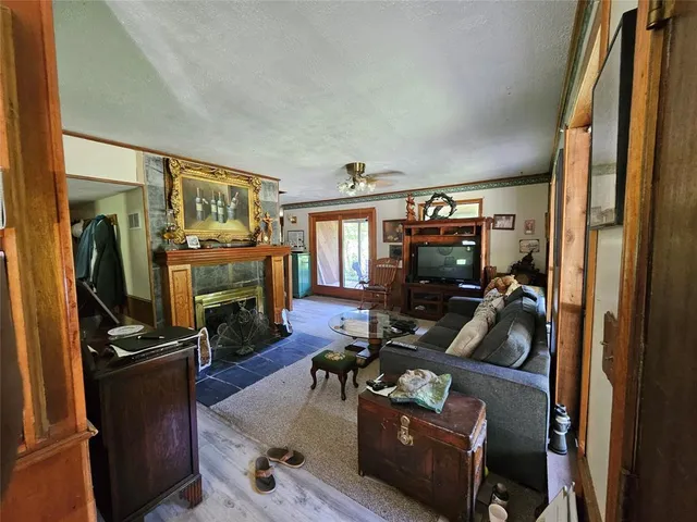 a living room with furniture a flat screen tv and a refrigerator