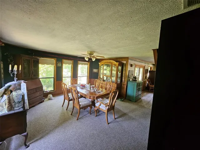 a dining room with furniture and a floor to ceiling window