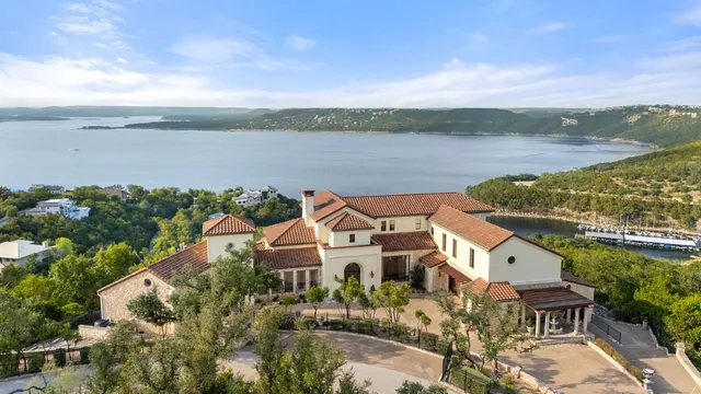 an aerial view of a house with a garden and lake view