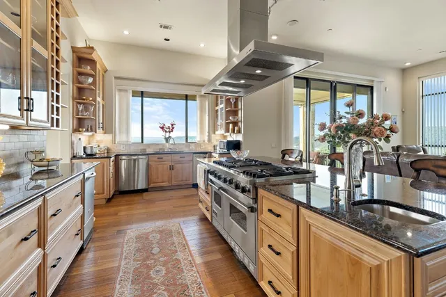 a kitchen with stainless steel appliances granite countertop a sink and stove