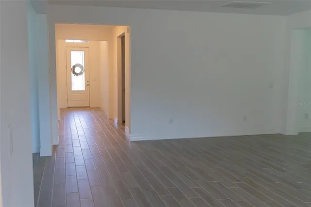 a view of a room with wooden floor and a window