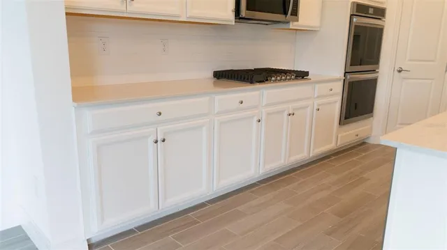 a kitchen with white cabinets and white appliances