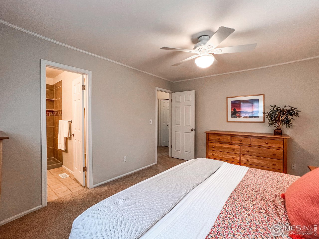 645 Cree Circle Boulder, CO 80303 - Photo 17 of 40 a bedroom with a bed and a chandelier