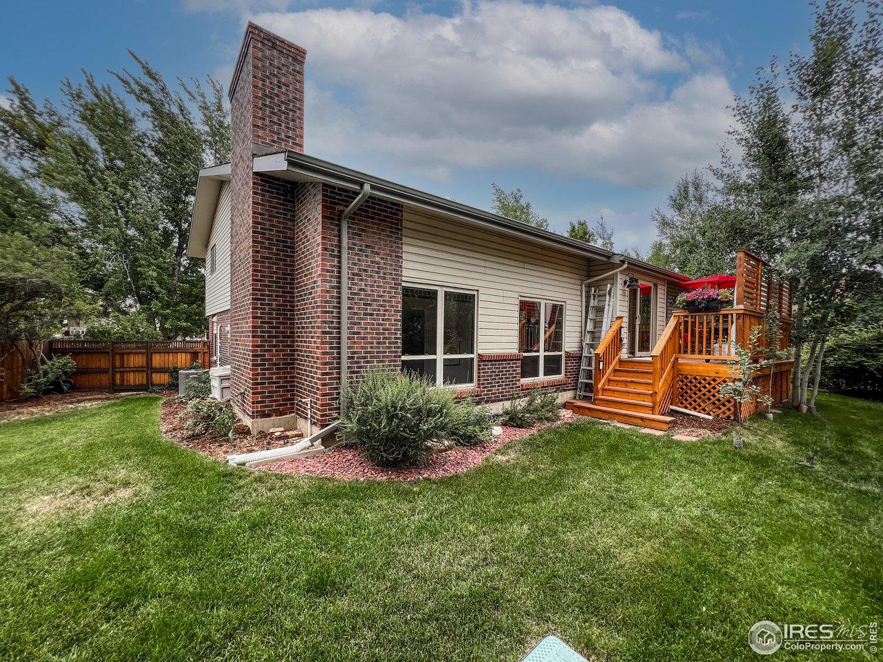 645 Cree Circle Boulder, CO 80303 - Photo 35 of 40 a backyard of a house with table and chairs plants and large tree