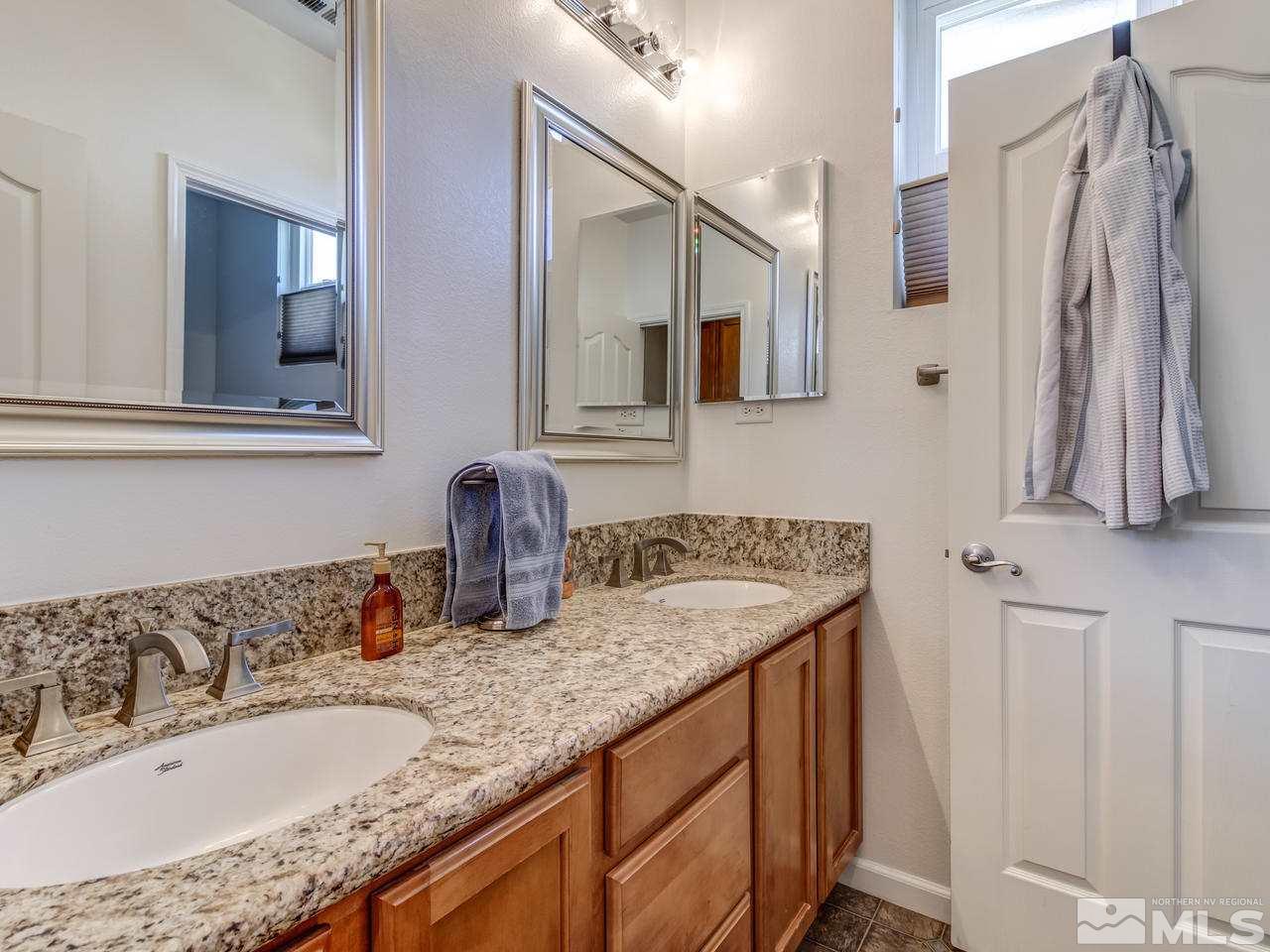 417 Alysheba Court Reno, NV 89521 - Photo 16 of 25 a bathroom with a granite countertop sink and a mirror