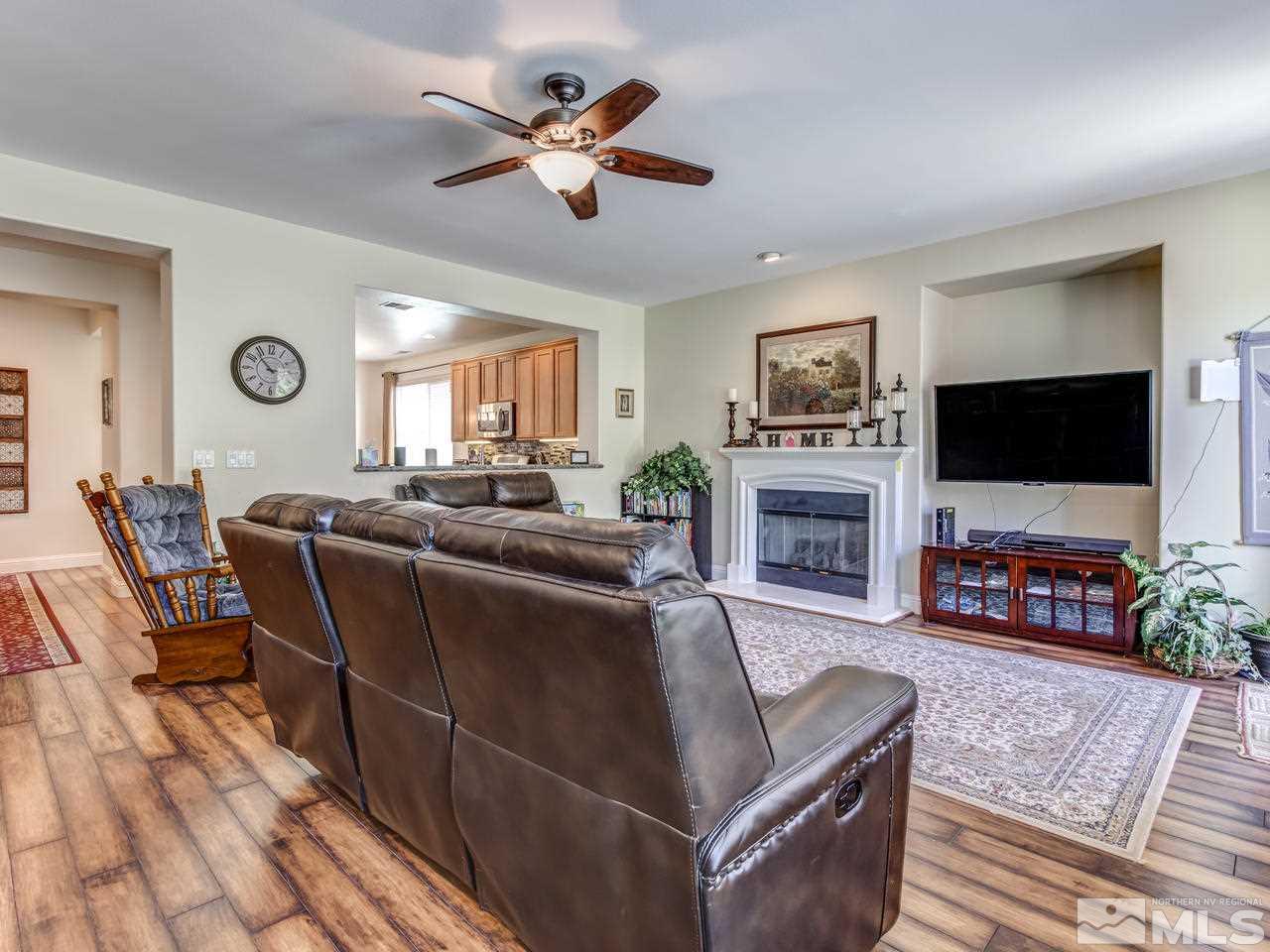 417 Alysheba Court Reno, NV 89521 - Photo 5 of 25 a living room with furniture a flat screen tv and a fireplace