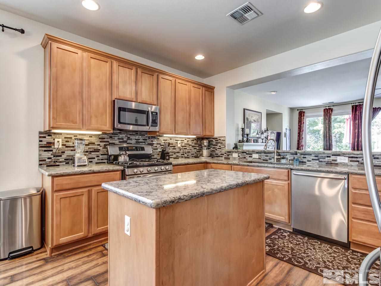 417 Alysheba Court Reno, NV 89521 - Photo 8 of 25 a kitchen with stainless steel appliances granite countertop a stove a sink and a microwave