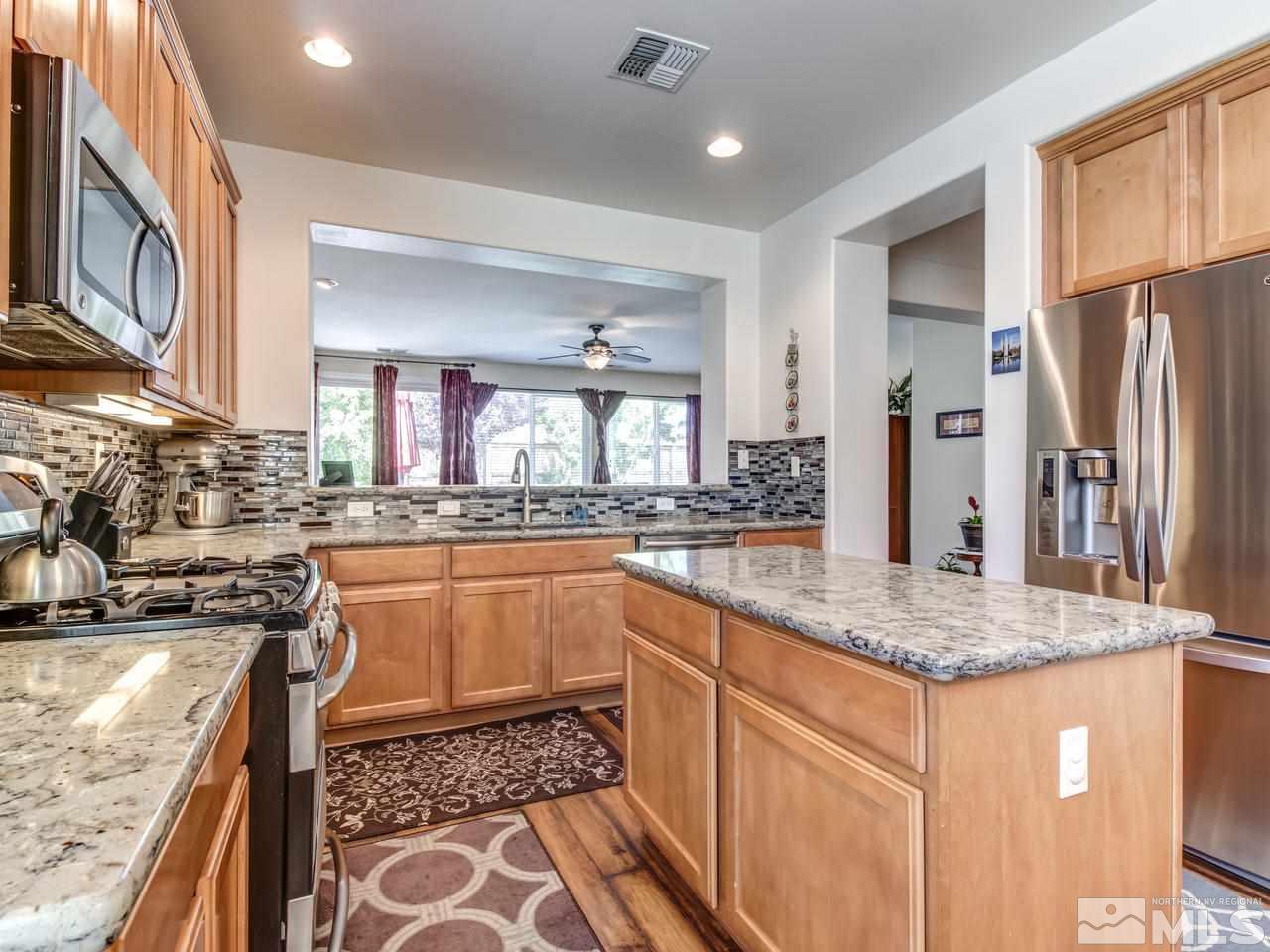417 Alysheba Court Reno, NV 89521 - Photo 9 of 25 a kitchen with stainless steel appliances granite countertop a sink stove and refrigerator