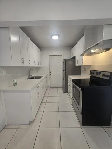 a kitchen with a sink a stove and cabinets
