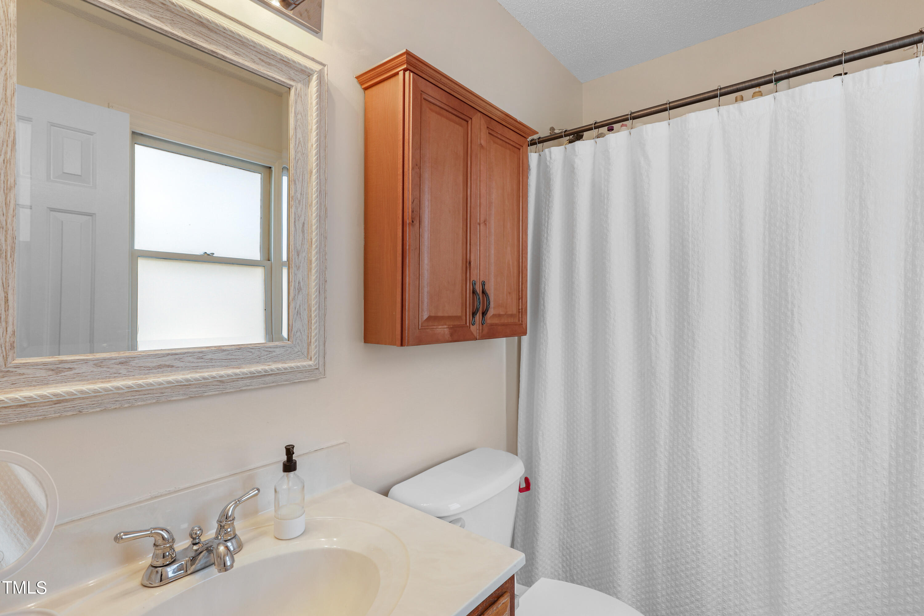 3632 Epperly Court Raleigh, NC 27616 - Photo 21 of 26 a bathroom with a sink and a shower curtain