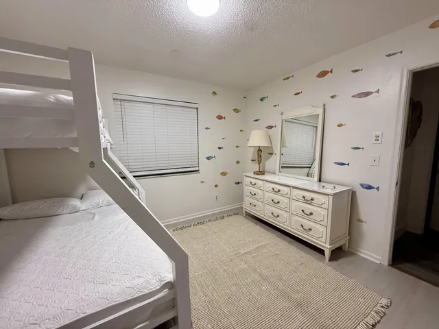 a spacious bathroom with double sink a toilet a shower and a window