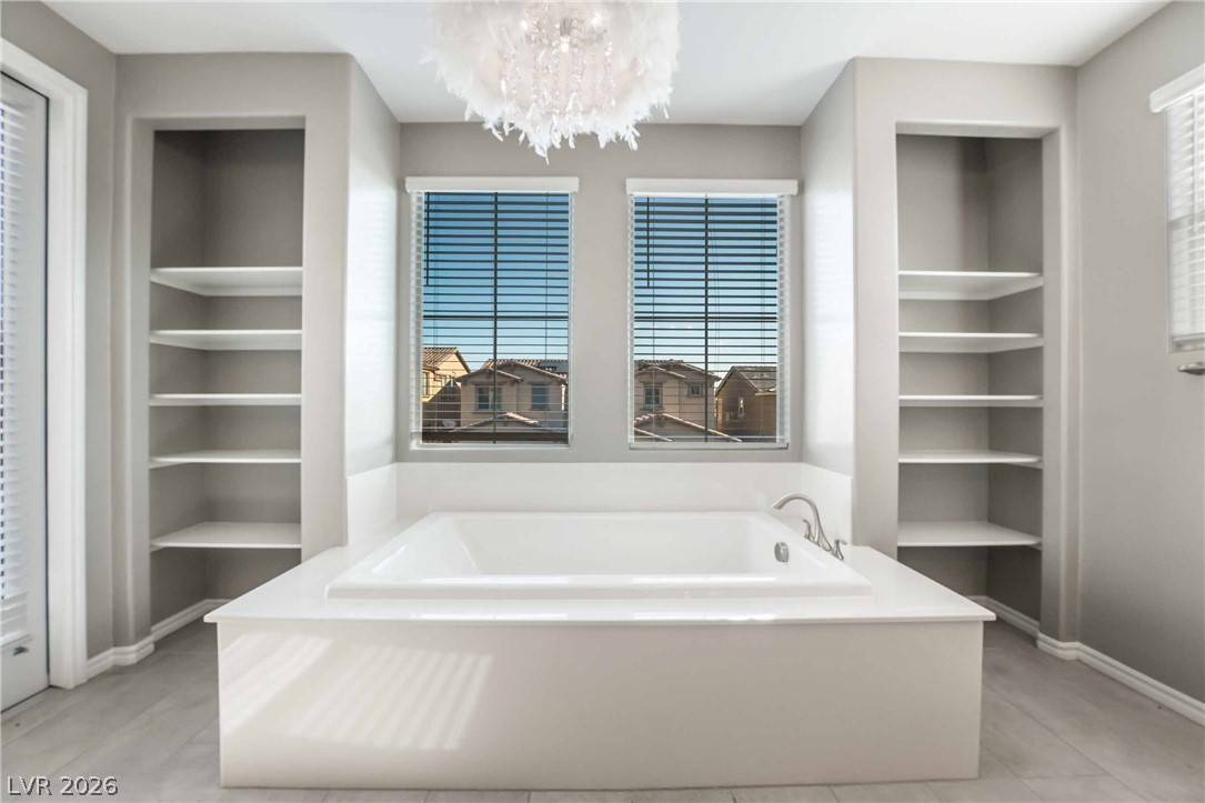 2787 Athens Ridge Drive Henderson, NV 89052 - Photo 18 of 31 Relax in this luxurious soaking tub, flanked by custom built-in shelving, offering a private oasis.